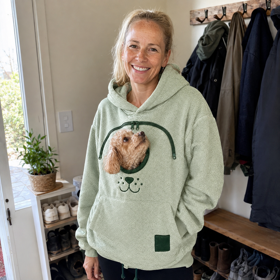 Pet parent wearing the Pet Carrier Hoodie with a small dog in the front pouch