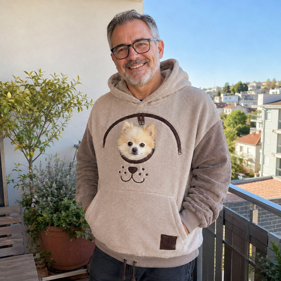 Pet parent on a balcony wearing the Pet Carrier Hoodie with a small dog in the pouch